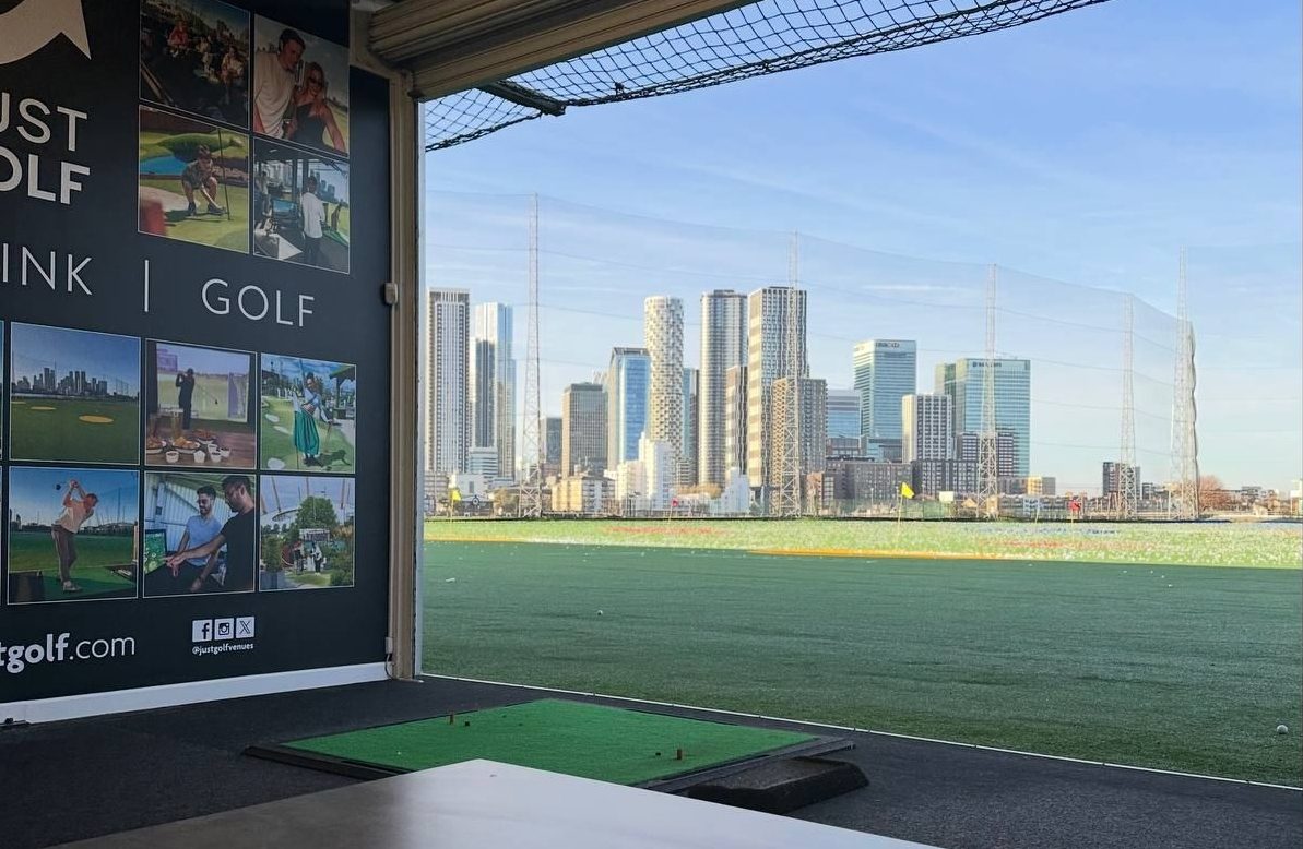 A bay at Greenwich Peninsula Golf Range, looking toward the Canary Wharf skyline